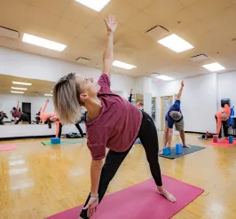 Adults doing yoga pose at group mind and body class at YMCA Louisville