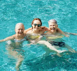 Three older women swimming in pool