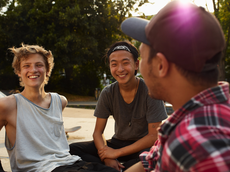 Young men sitting on the ground at a skateboard park Young men sitting on the ground at a skateboard park