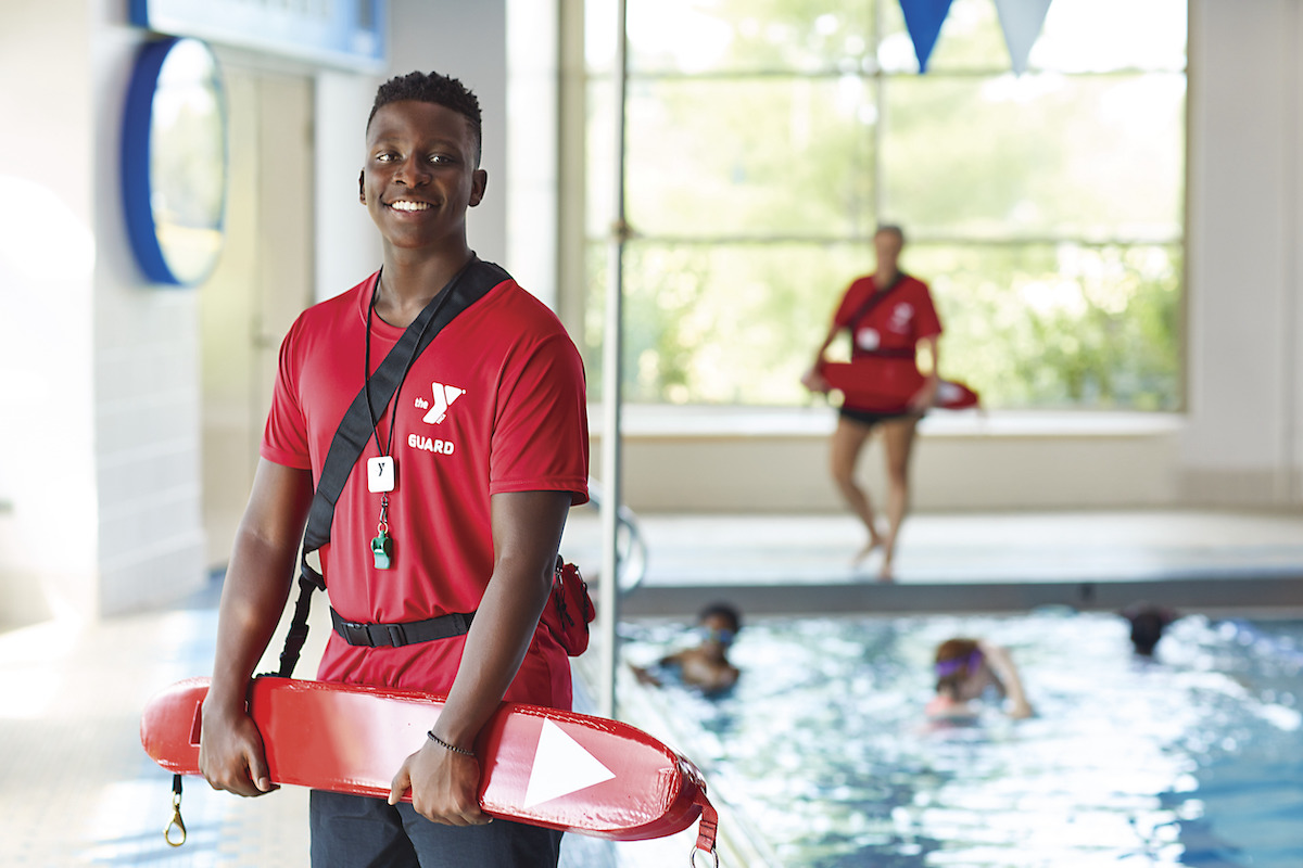 Two lifeguards and children swimming at YMCA swimming pool Two lifeguards and children swimming at YMCA swimming pool