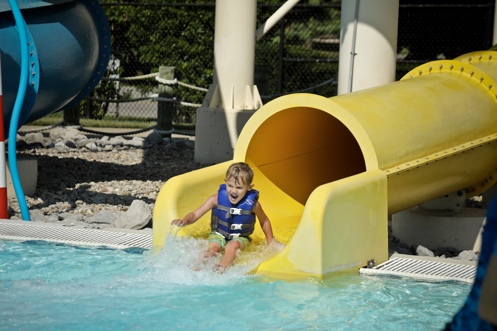 Child sliding down a water slide at YMCA Louisville Calypso Cove Waterpark