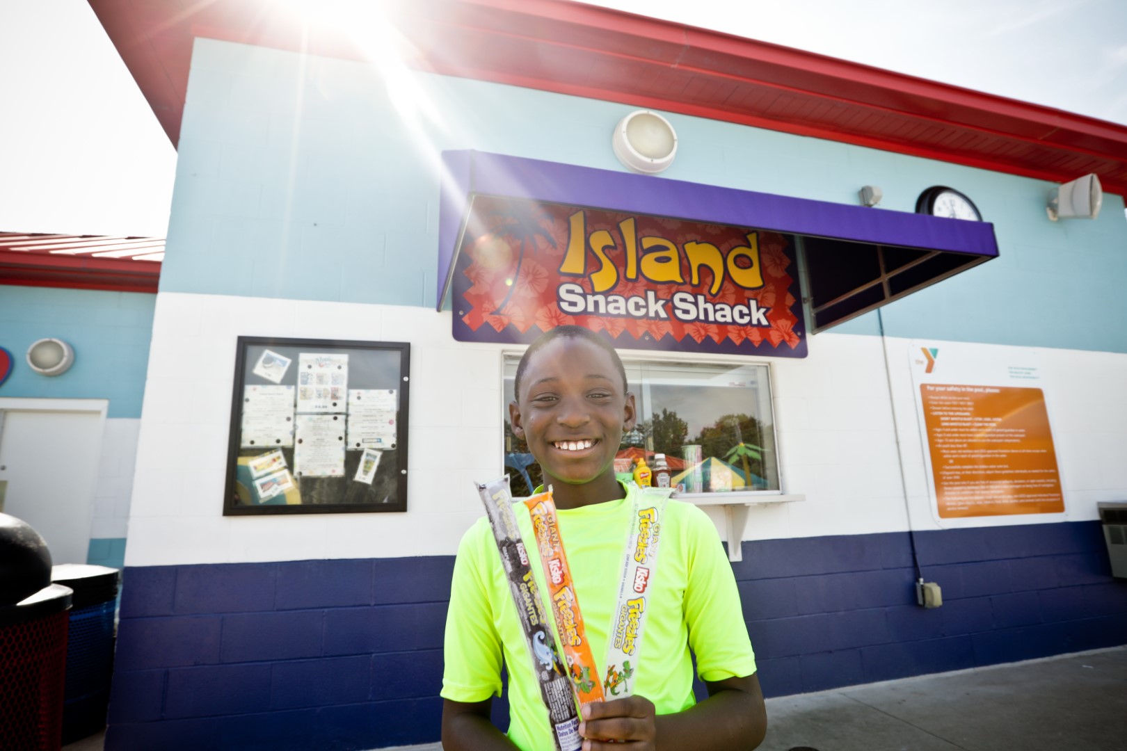Child with Freezies smiling in front of Island Snack Shack Calypso Cove Waterpark