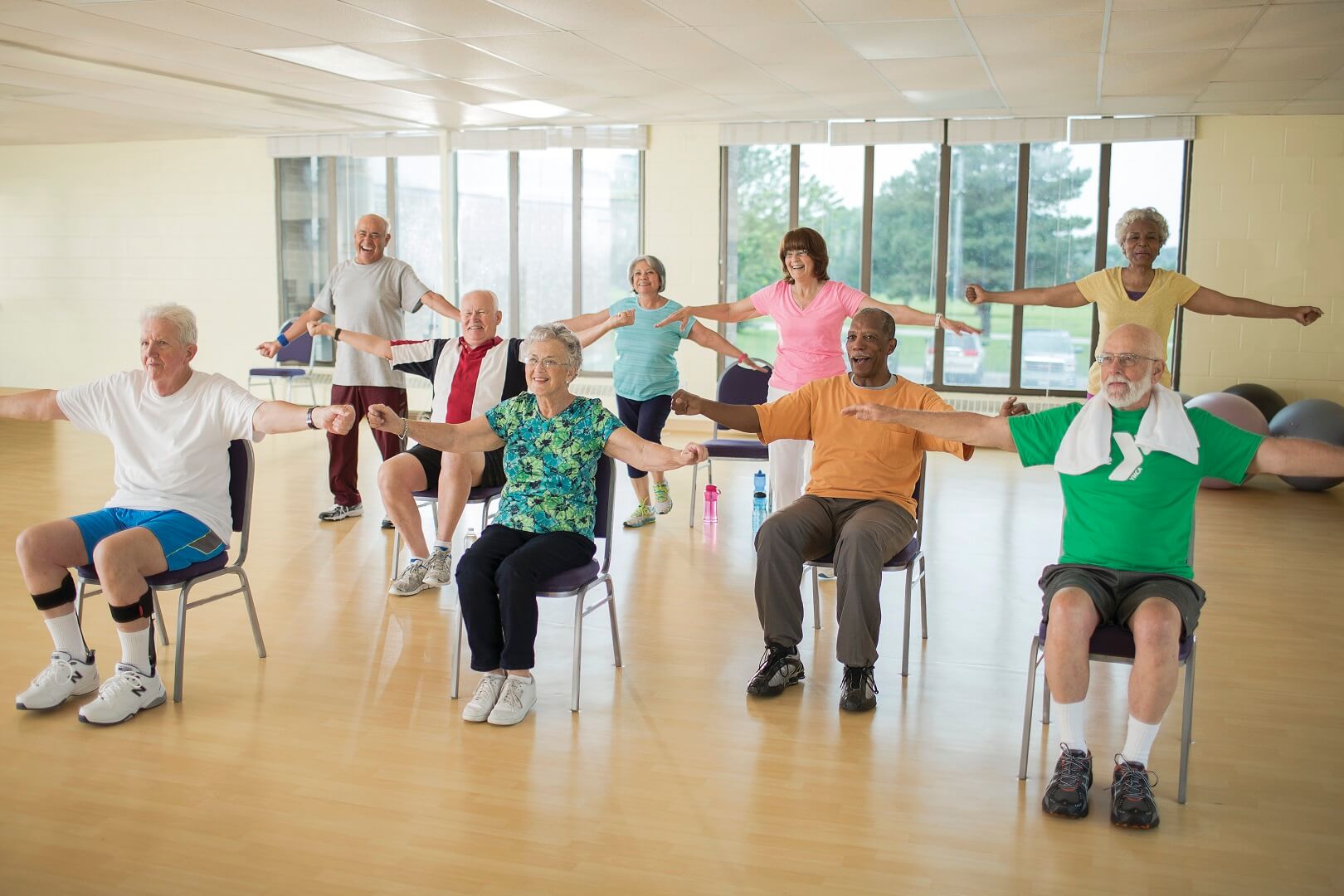 Group of older adults doing arm exercises at YMCA Louisville Forever Young fitness class Group of older adults doing arm exercises at YMCA Louisville Forever Young fitness class