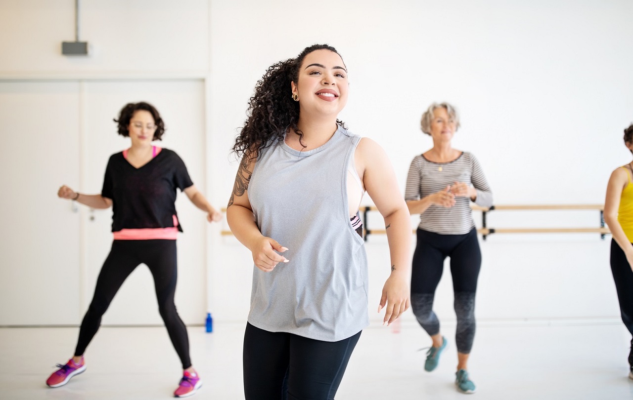 Adults and instructor flexing at group dance class at YMCA Louisville Adults and instructor flexing at group dance class at YMCA Louisville