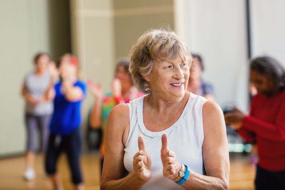 Older YMCA member smiling and clapping hands Older YMCA member smiling and clapping hands