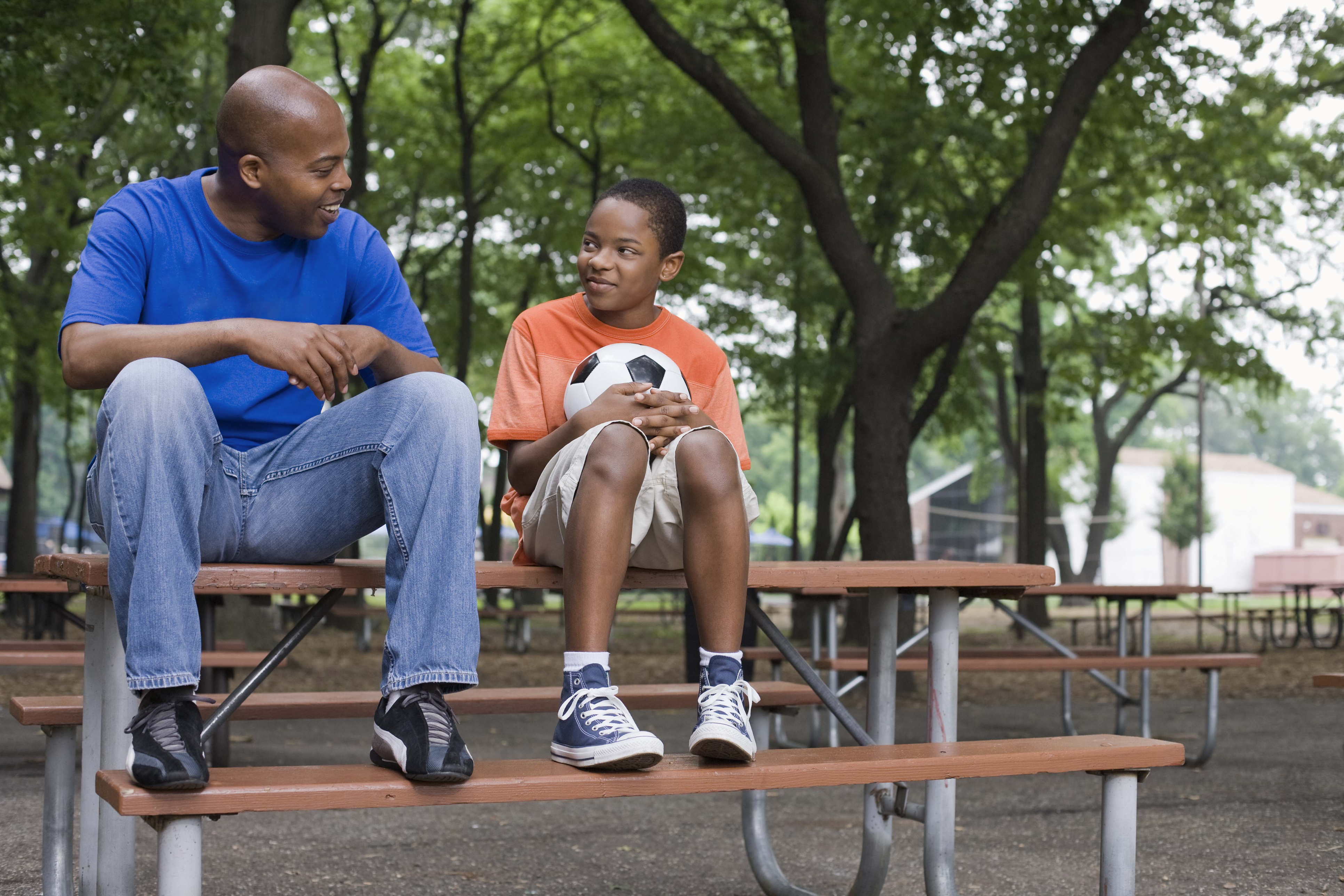 Parent and child sitting on a picnic table sharing a quiet moment after Y-NOW mentoring at YMCA Safe Place Services Parent and child sitting on a picnic table sharing a quiet moment after Y-NOW mentoring at YMCA Safe Place Services