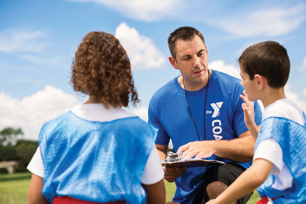 Coach talking to kids for YMCA Louisville youth fitness program Coach talking to kids for YMCA Louisville youth fitness program
