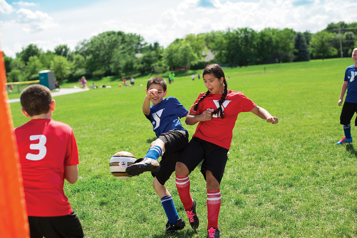 Kids playing in youth soccer league game Kids playing in youth soccer league game