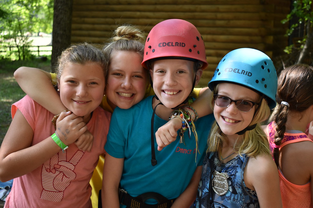 Kids posing for a picture together before climbing a ropes course Kids posing for a picture together before climbing a ropes course