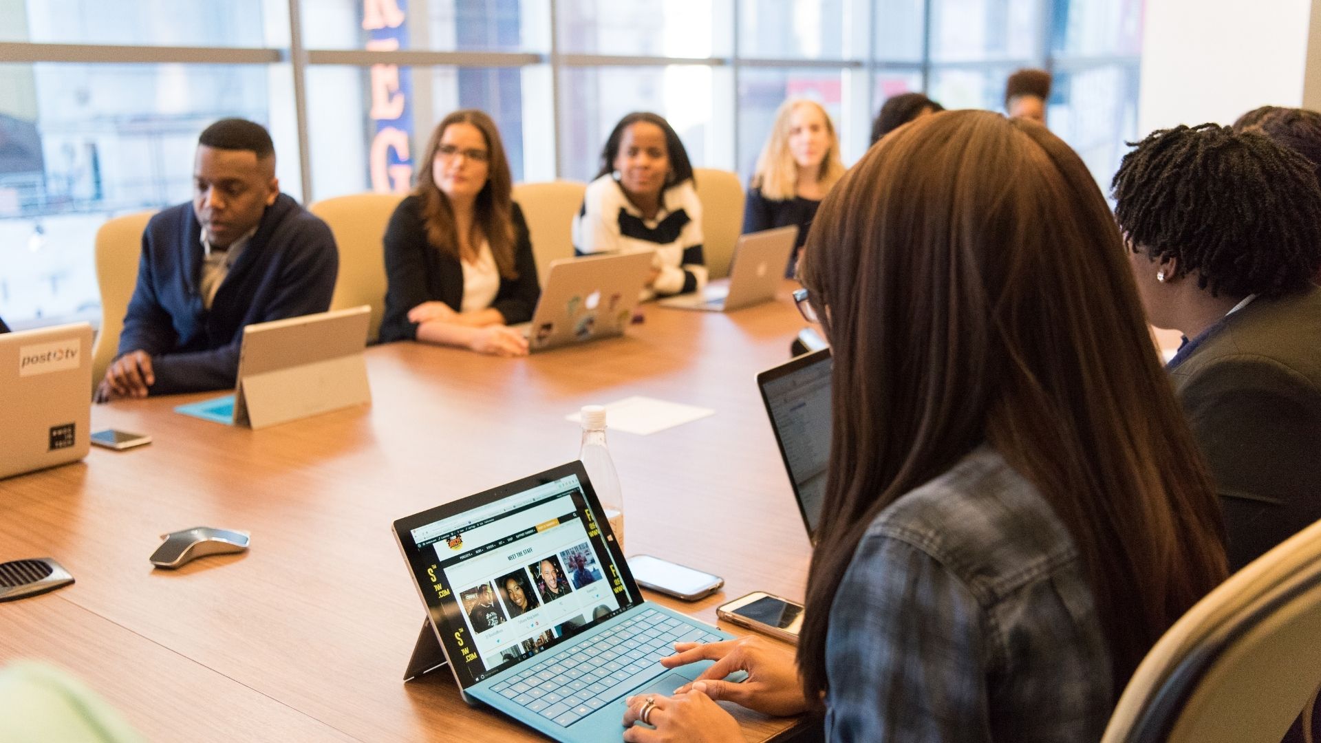 Group of people on computers in a meeting room Group of people on computers in a meeting room