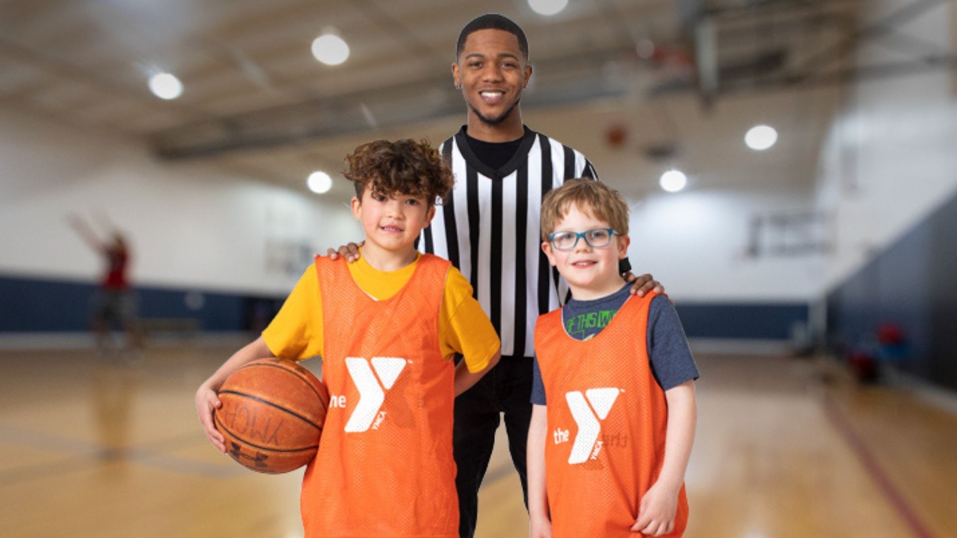 Smiling referee standing with two young basketball players Smiling referee standing with two young basketball players