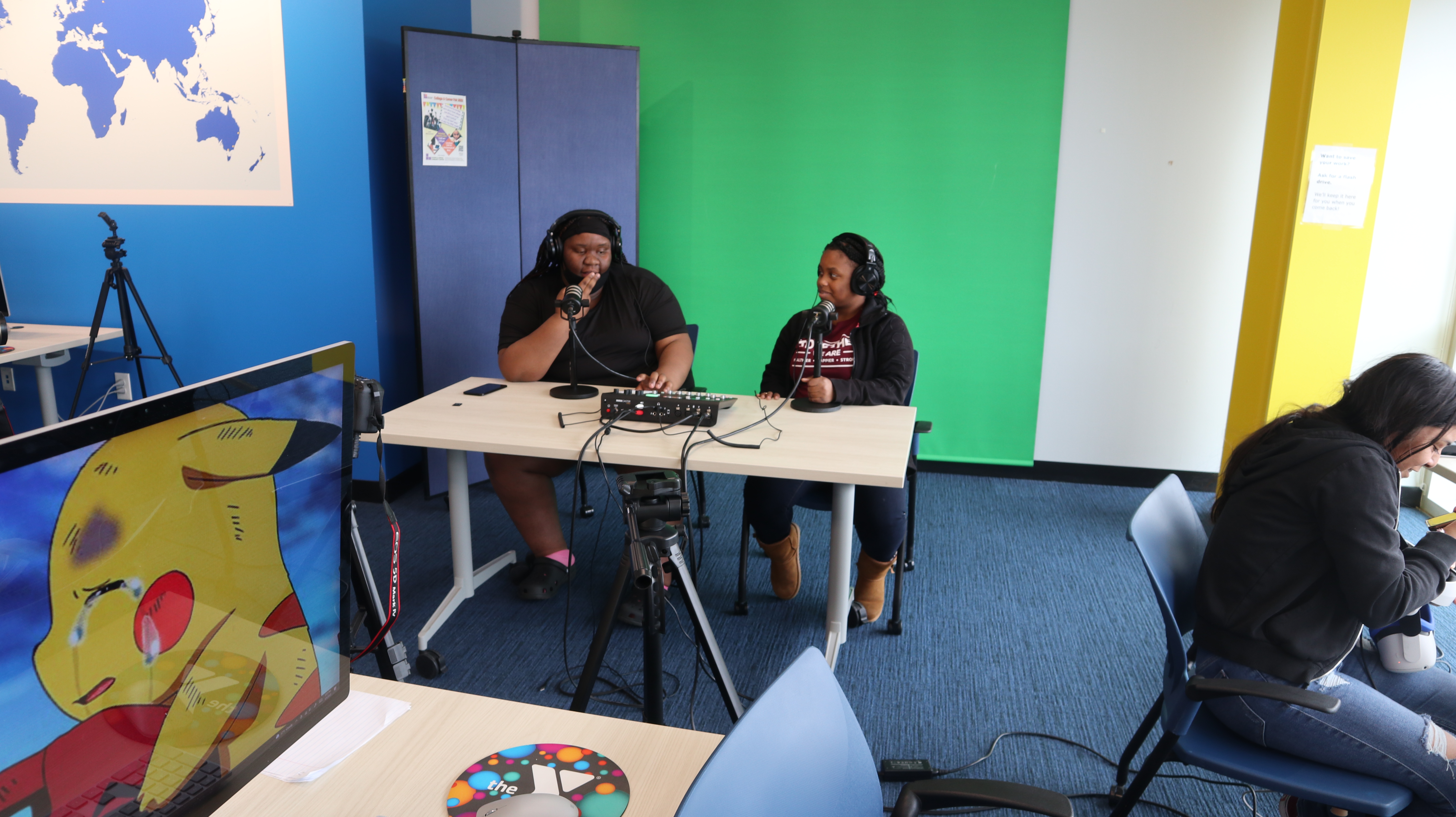 2 teens sitting at a desk recording a podcast 2 teens sitting at a desk recording a podcast