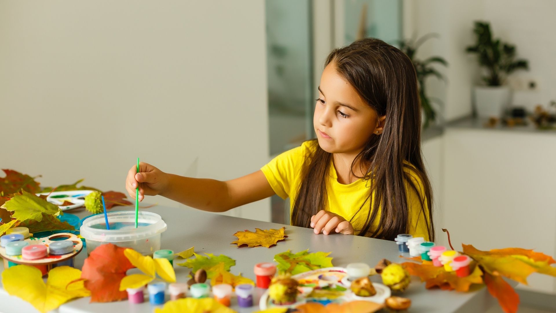 Young girl sitting at table painting Young girl sitting at table painting