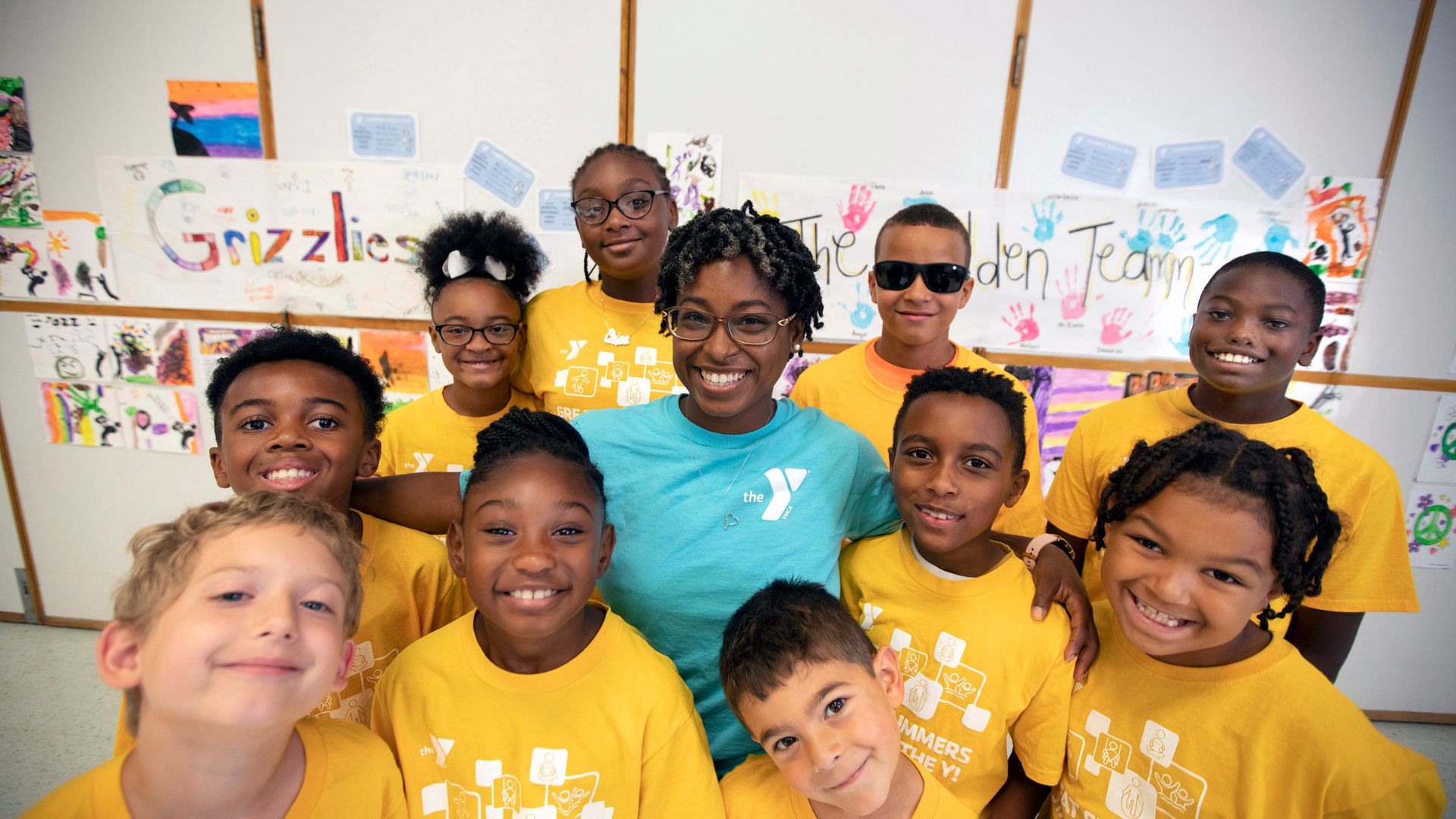 Child care staff member standing with a group of children Child care staff member standing with a group of children