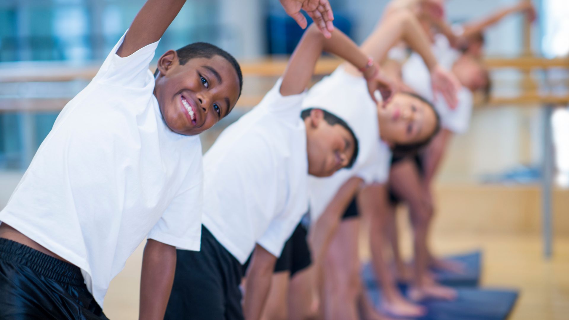 Group of kids stretching before participating in sports Group of kids stretching before participating in sports