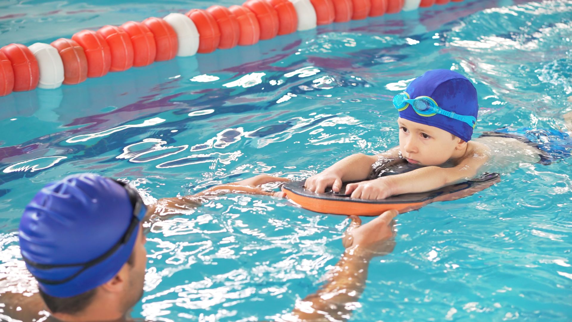 Child in the pool swimming to an instructor Child in the pool swimming to an instructor