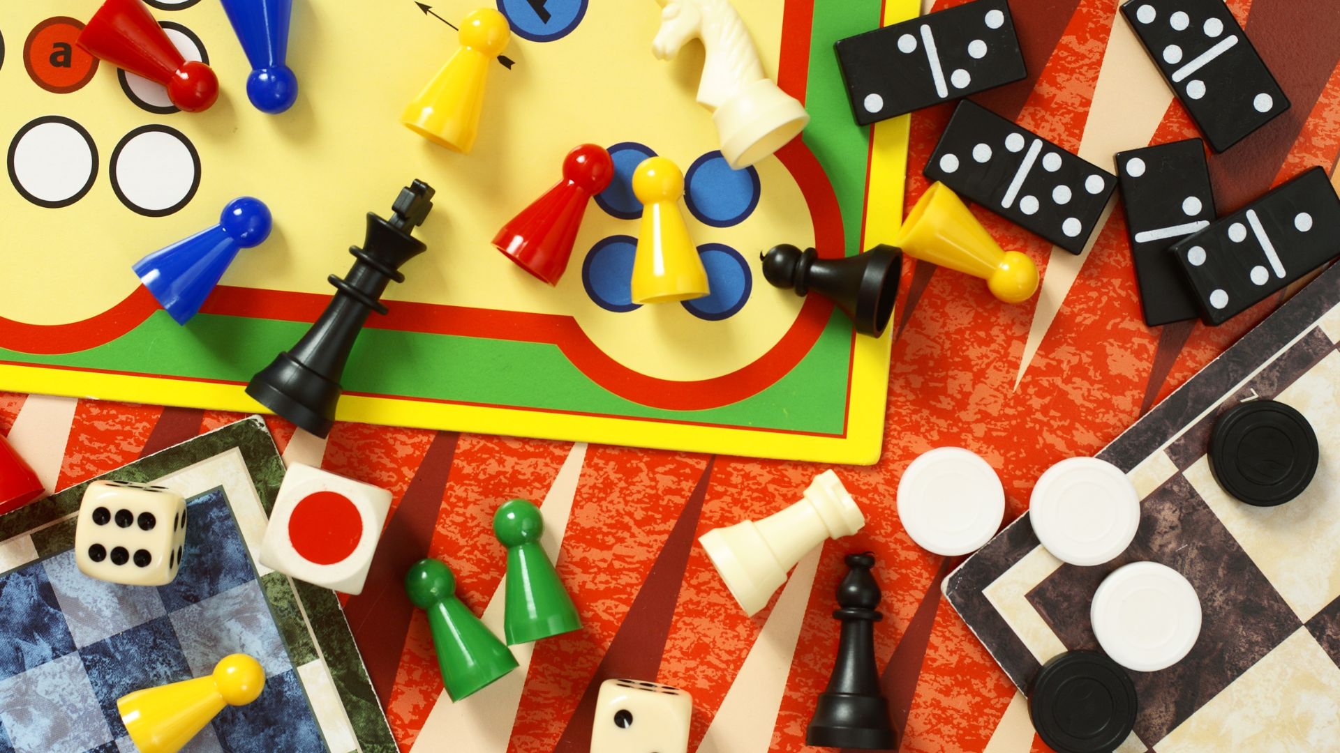 Board game materials and pieces on a table Board game materials and pieces on a table