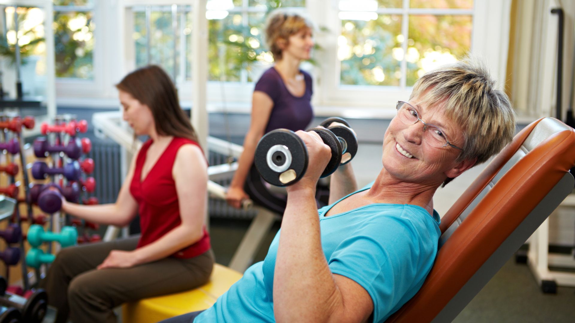 Women of various ages in the gym lifting weights Women of various ages in the gym lifting weights
