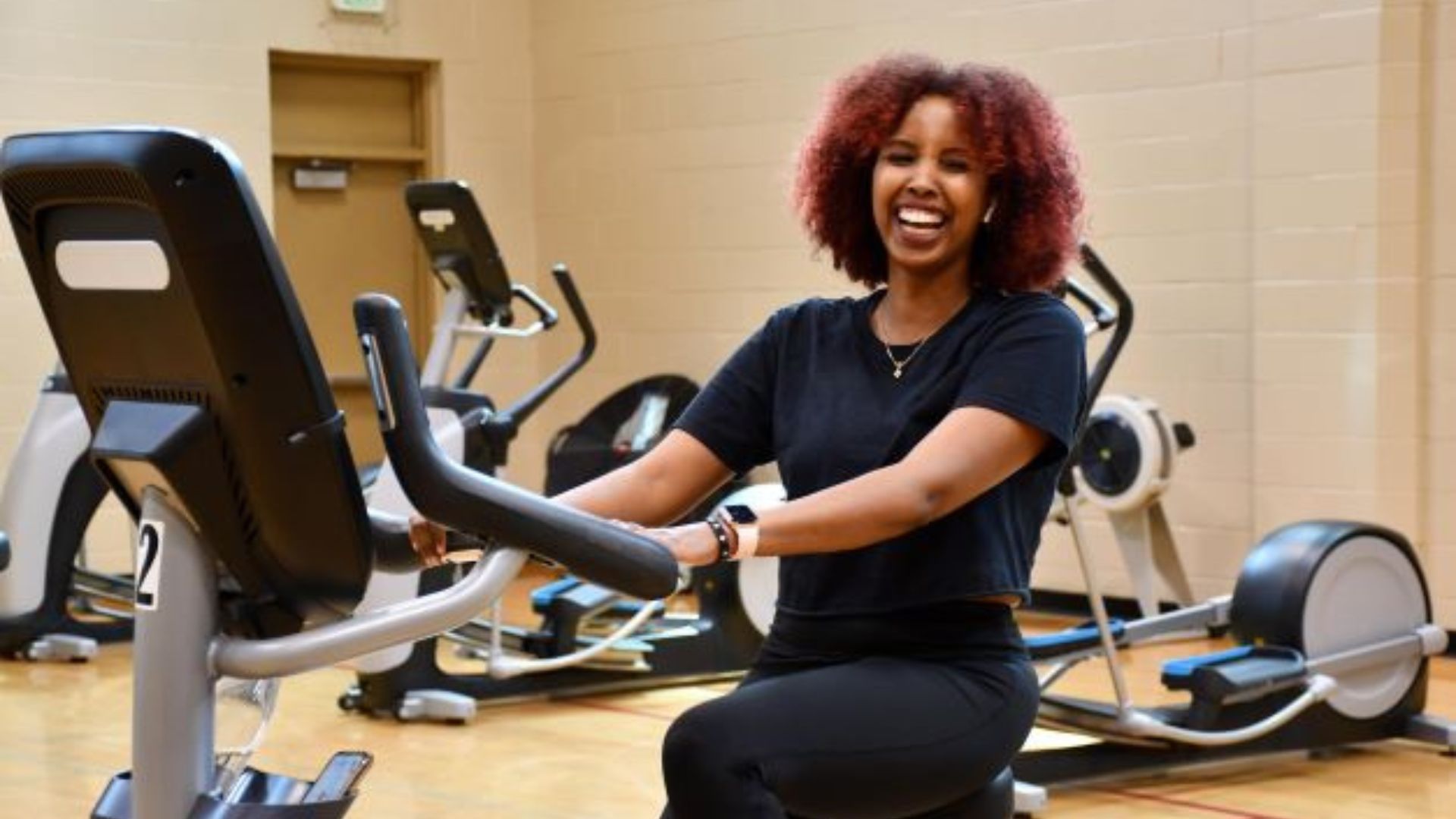 Smiling woman exercising on a spin bike at the YMCA Smiling woman exercising on a spin bike at the YMCA