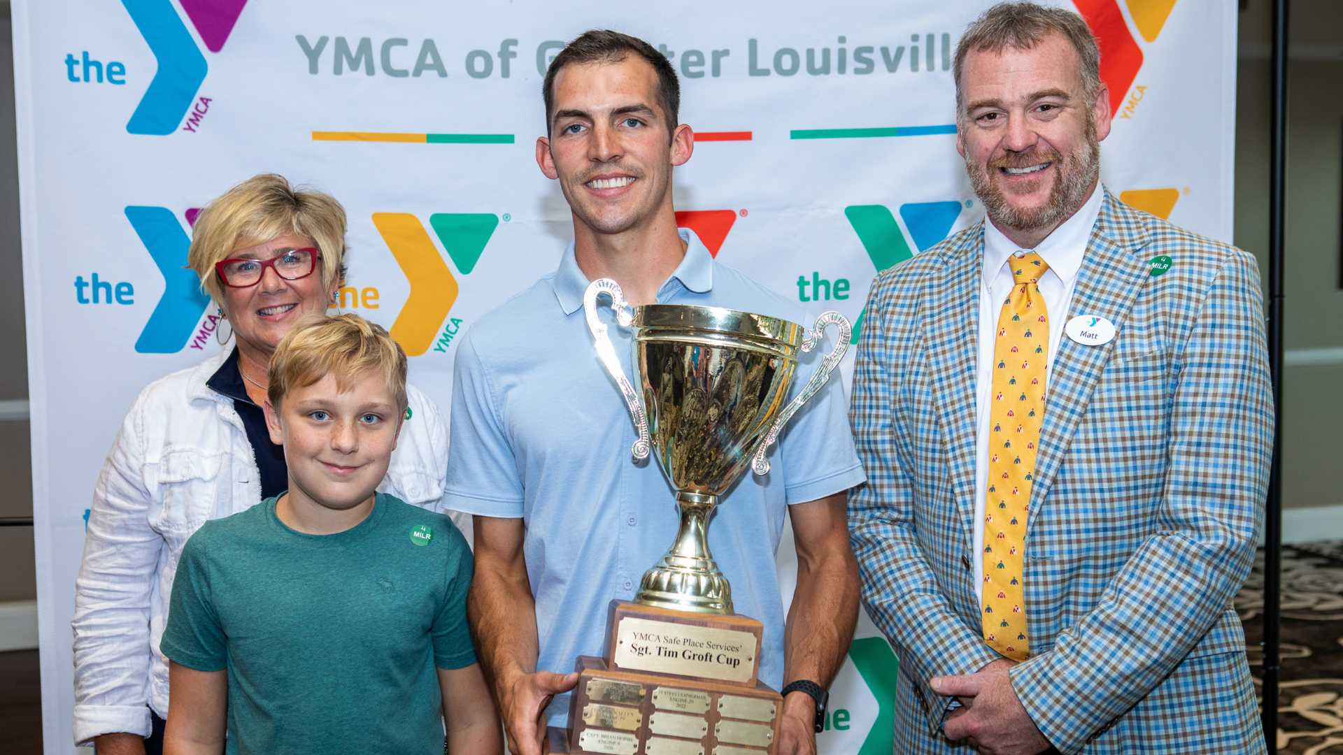 Group of people smiling with trophy