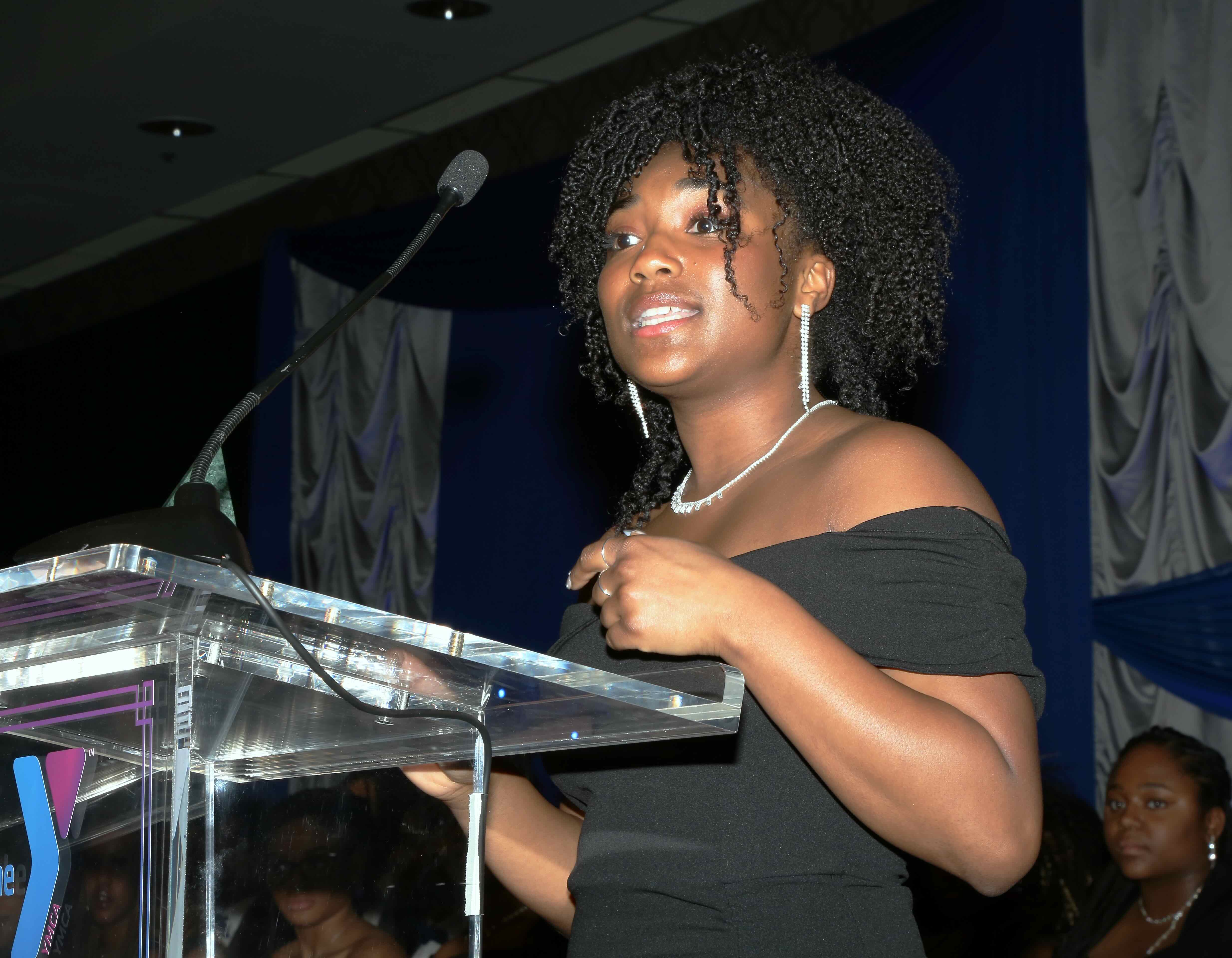 Young woman standing on a podium giving a speech