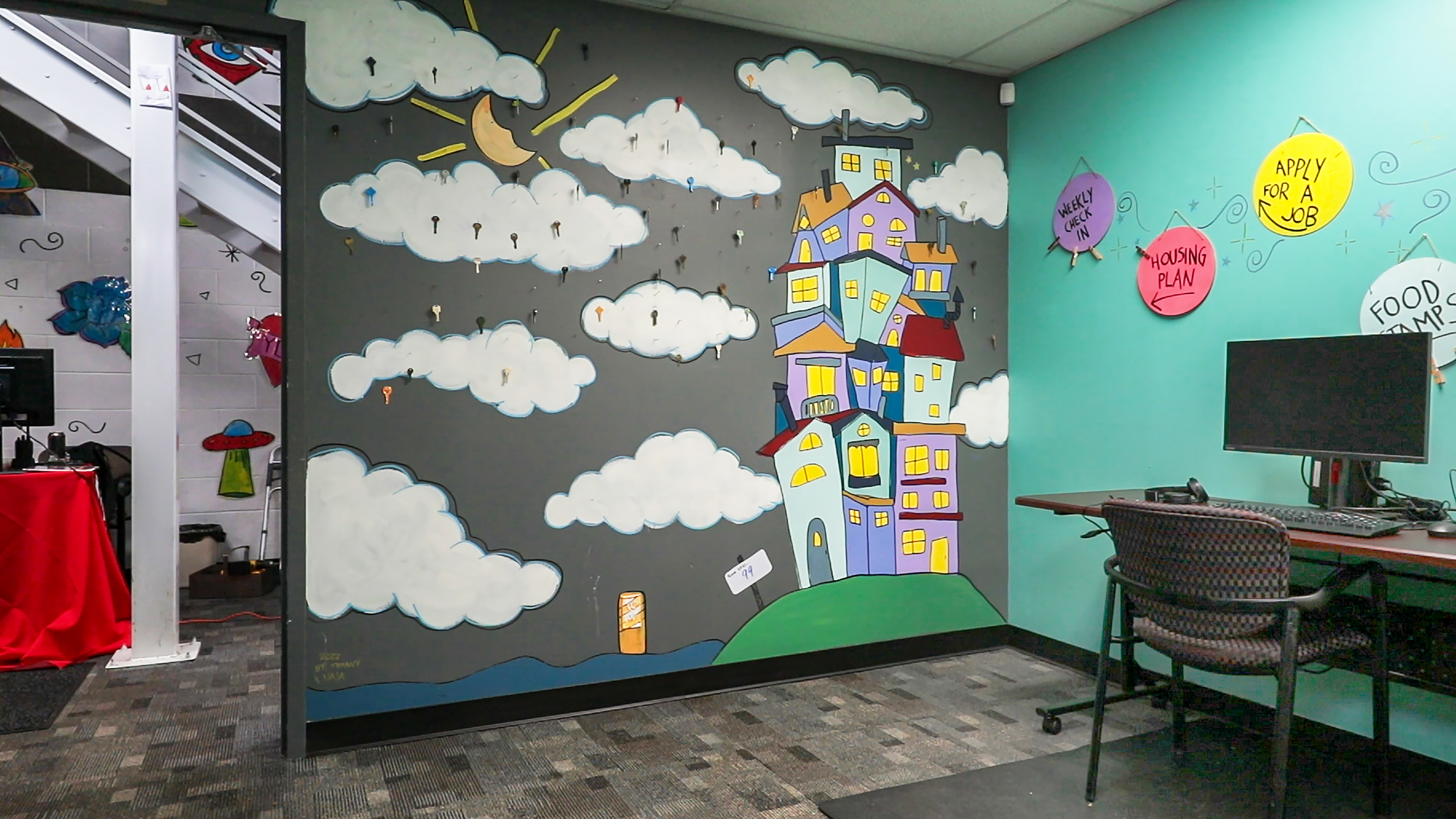 Painted mural of clouds and buildings on a wall 