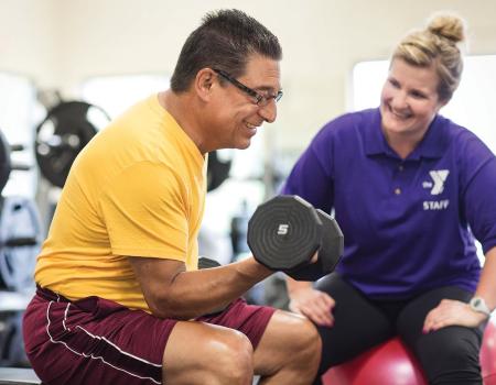 Man and instructor doing strength training at YMCA Louisville Man and instructor doing strength training at YMCA Louisville