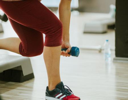 Person lifting a handweight on a workout step