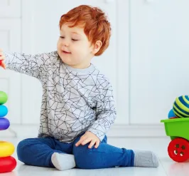 Toddler playing a game stacking rings on a cone