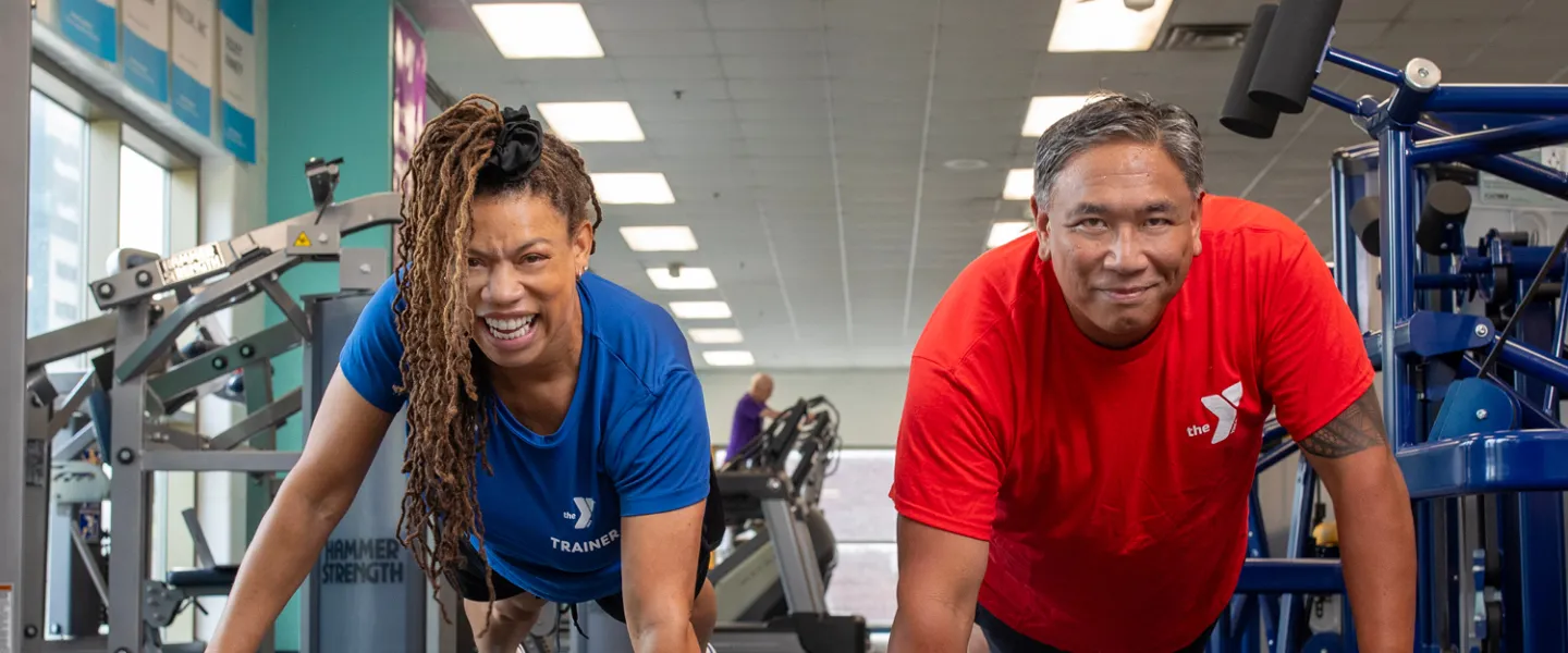Personal trainer and member exercising with medicine balls