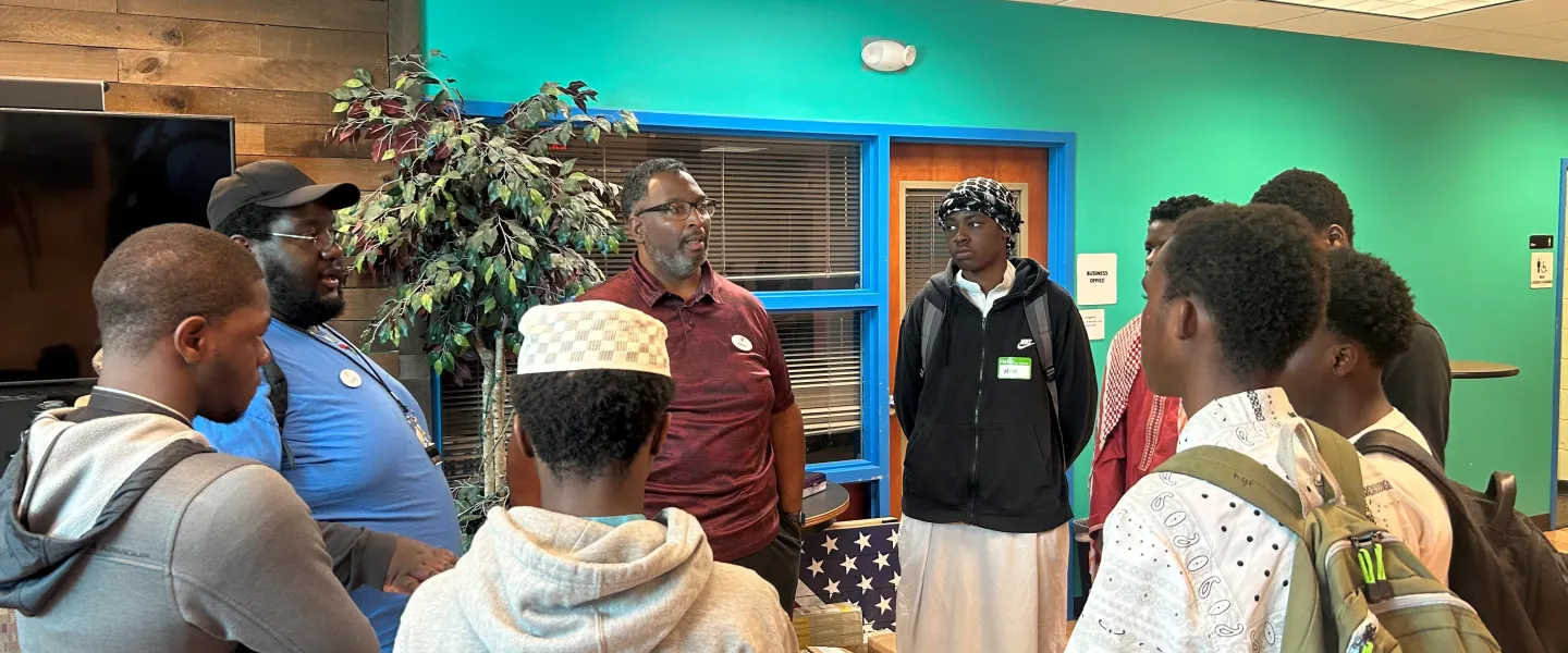 Group of teens listening to an adult talking