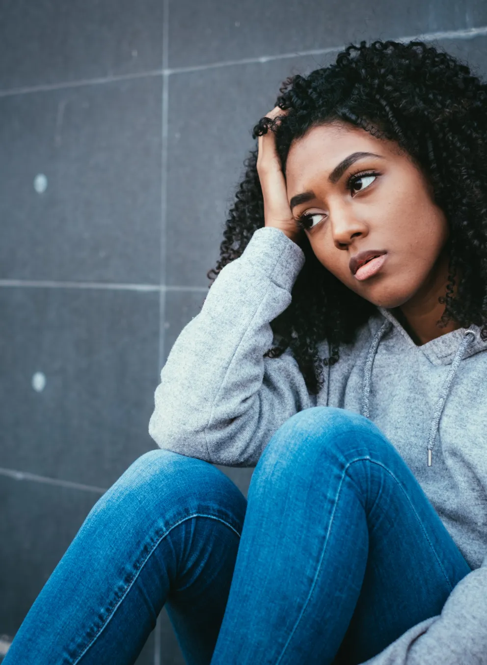 Teen sitting on the floor looking forlorn