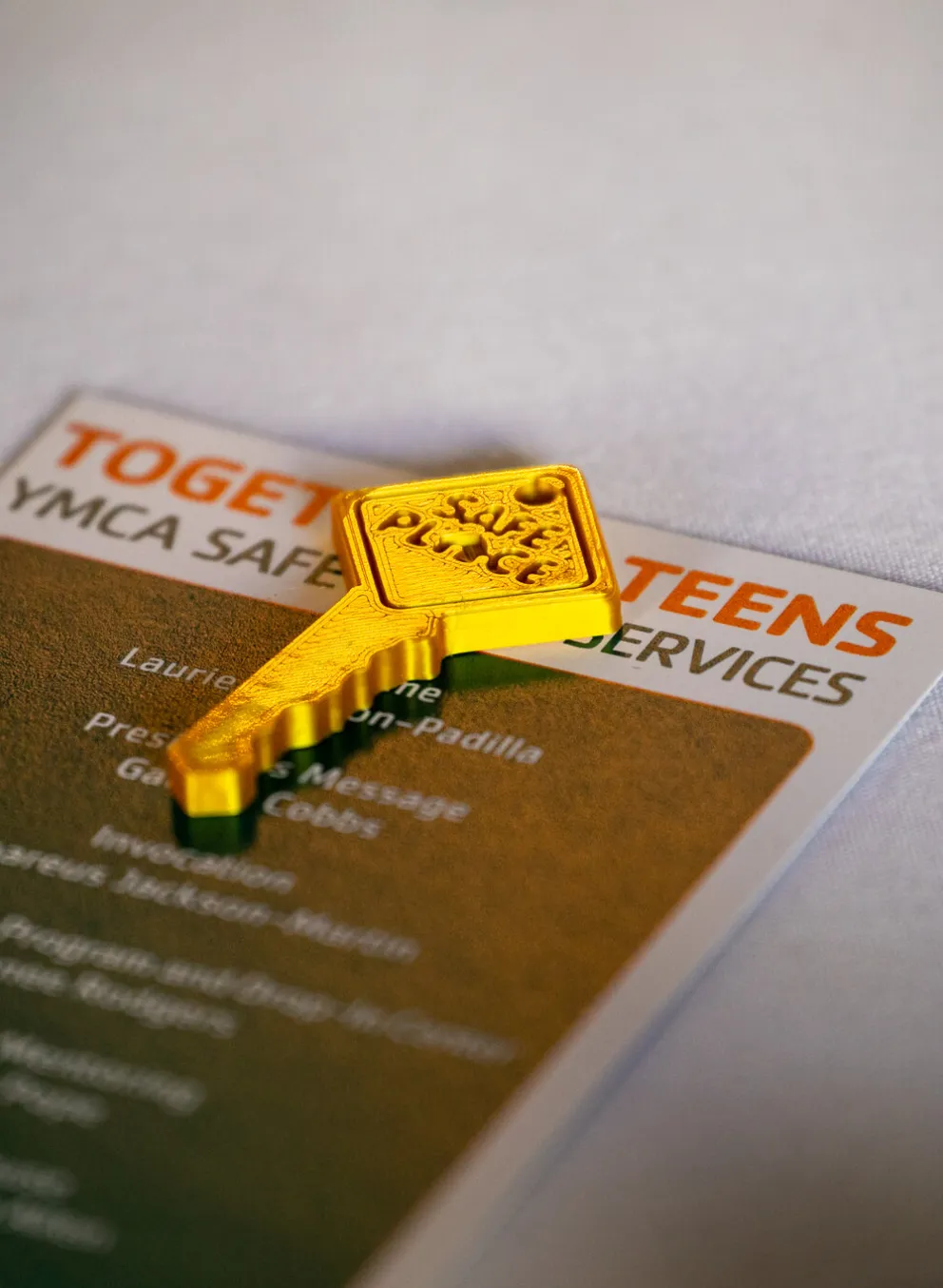 Gold key places on top of a table with Together 4 Teens brochure