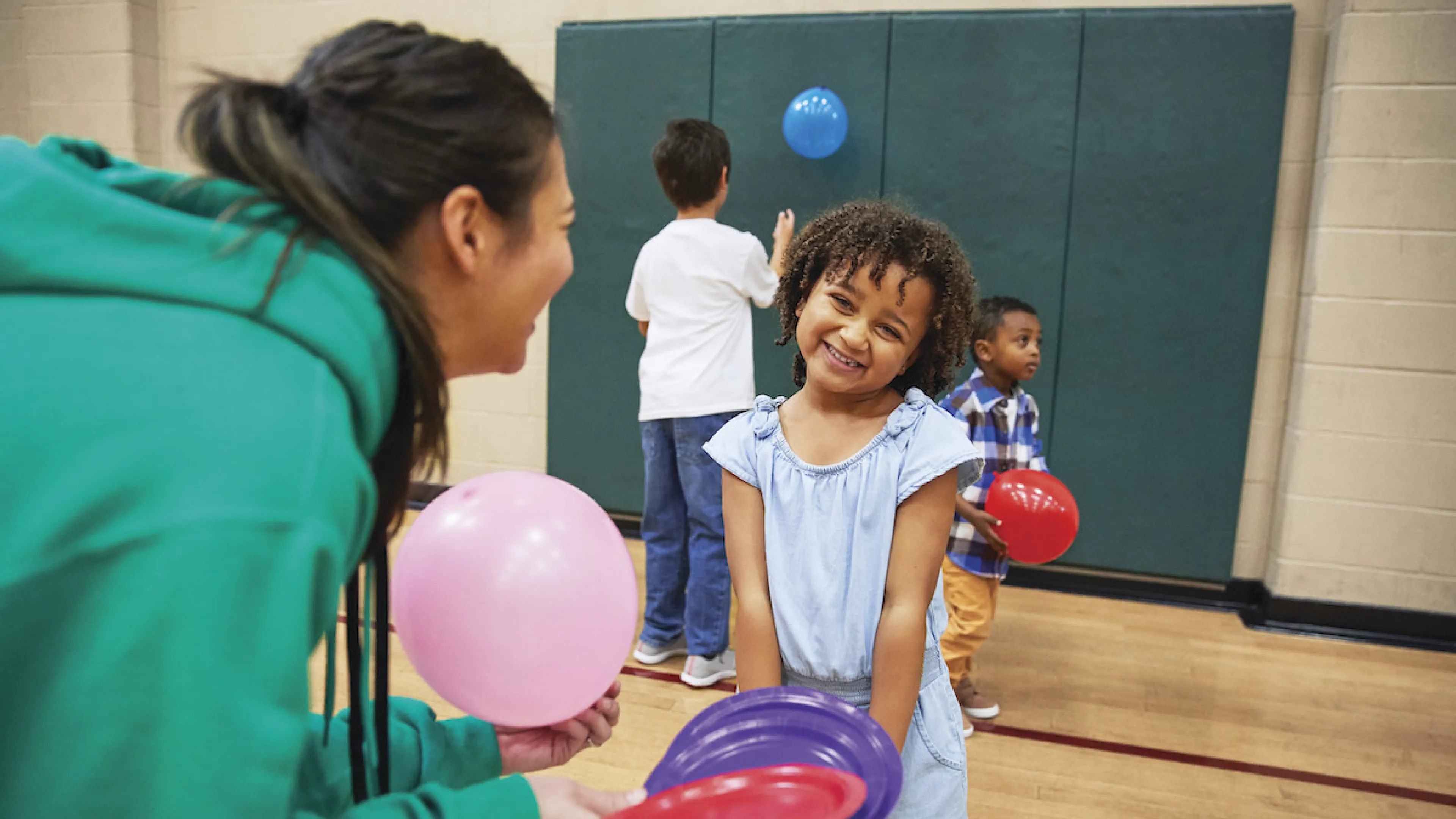 YMCA teen playing with little girl after school