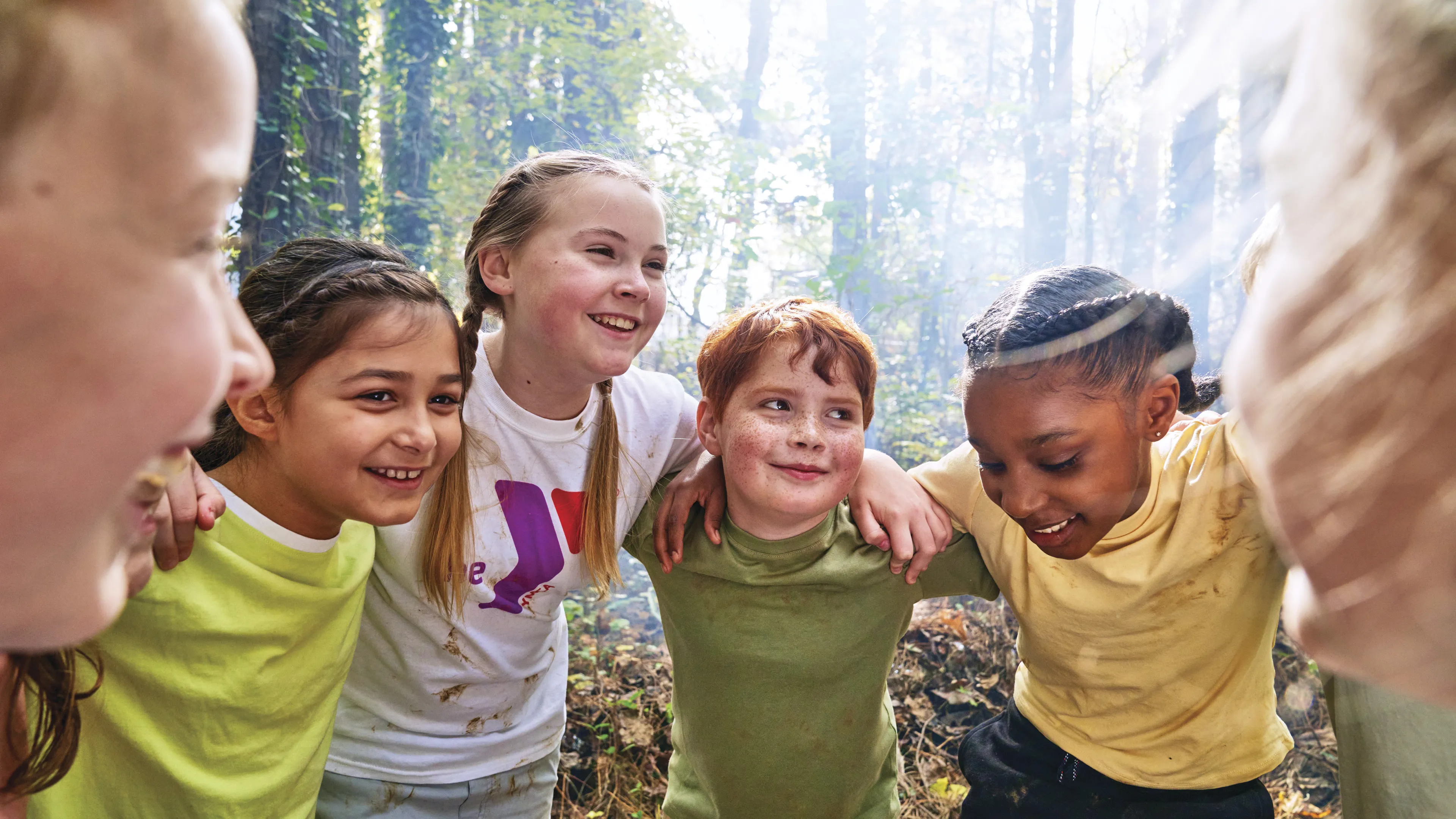 Group of kids outdoors in a circle smiling