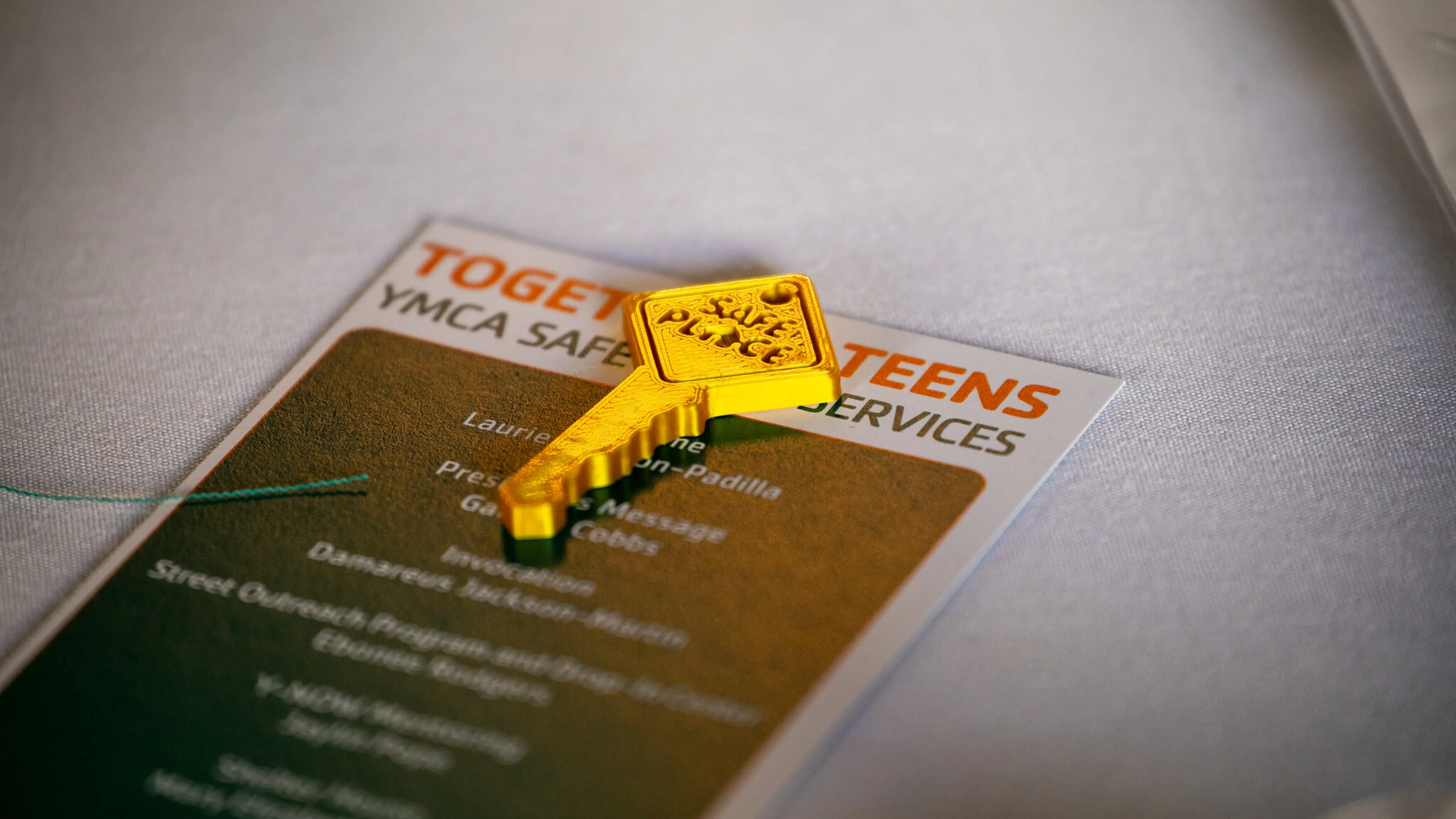 Gold key places on top of a table with Together 4 Teens brochure