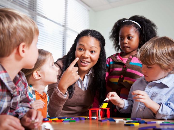 Kids and staff member making crafts at YMCA child enrichment program