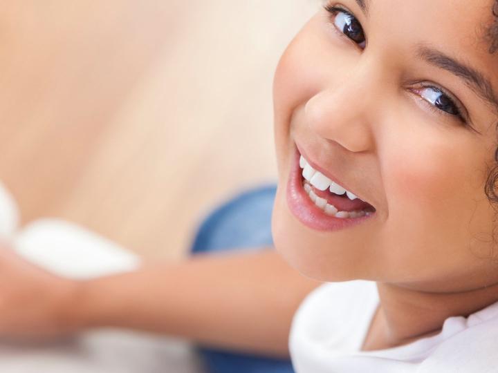 Close up of smiling young girl holding a book