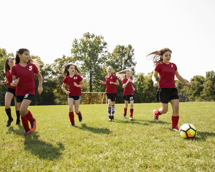 YMCA Louisville kids playing soccer outside through youth development programs YMCA Louisville kids playing soccer outside through youth development programs