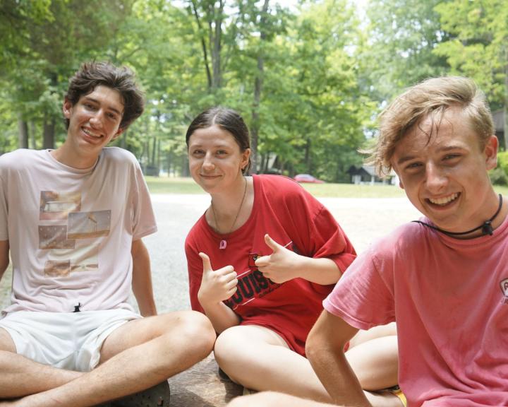 3 campers sitting outside together at YMCA Camp Piomingo