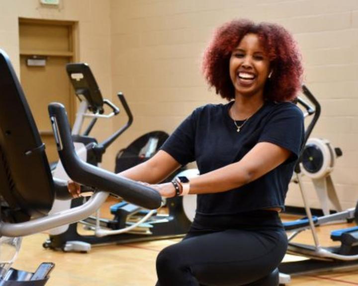 Smiling woman exercising on a spin bike at the YMCA