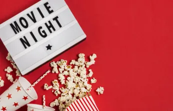 Movie night sign with popcorn and drink cups with straws