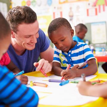 YMCA staff coloring with kids at YMCA child care program YMCA staff coloring with kids at YMCA child care program