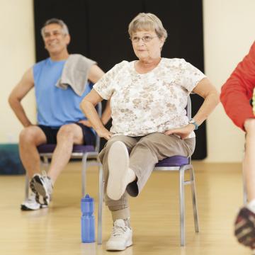 Older woman performing leg exercise at YMCA Louisville Forever Young fitness class Older woman performing leg exercise at YMCA Louisville Forever Young fitness class