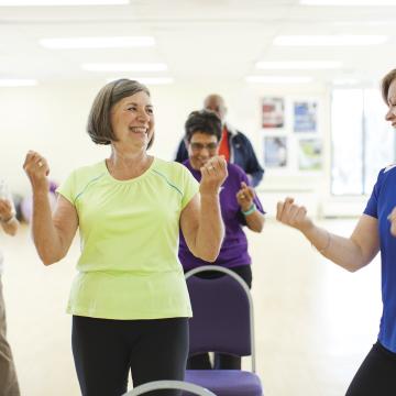 Adults and instructor flexing at group dance class at YMCA Louisville Adults and instructor flexing at group dance class at YMCA Louisville
