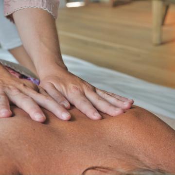 Hands massaging another person at a massage therapy session Hands massaging another person at a massage therapy session