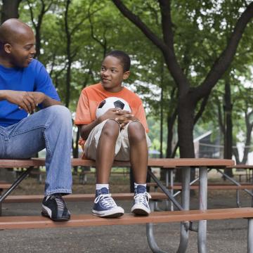 Parent and child sitting on a picnic table sharing a quiet moment after Y-NOW mentoring at YMCA Safe Place Services Parent and child sitting on a picnic table sharing a quiet moment after Y-NOW mentoring at YMCA Safe Place Services