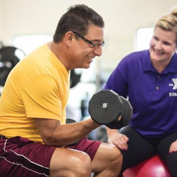 Person lifting weights during Smart Start fitness program at YMCA Louisville Person lifting weights during Smart Start fitness program at YMCA Louisville