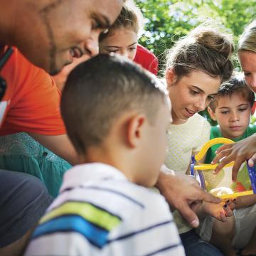 Children surrounding YMCA camp counselor at YMCA Louisville Summer Day Camps Children surrounding YMCA camp counselor at YMCA Louisville Summer Day Camps