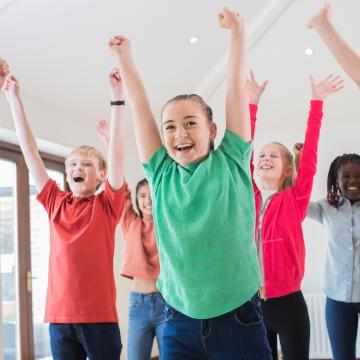 Kids raising hands in the air, celebrating and dancing together Kids raising hands in the air, celebrating and dancing together